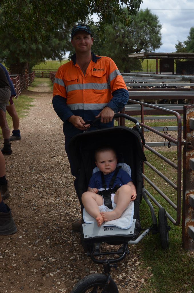 Stay-at-home dad Rick Thorne with son Liam waiting to sell some lambs at the weekly sheep sale. Photo Sophie Lester / Warwick Daily News
